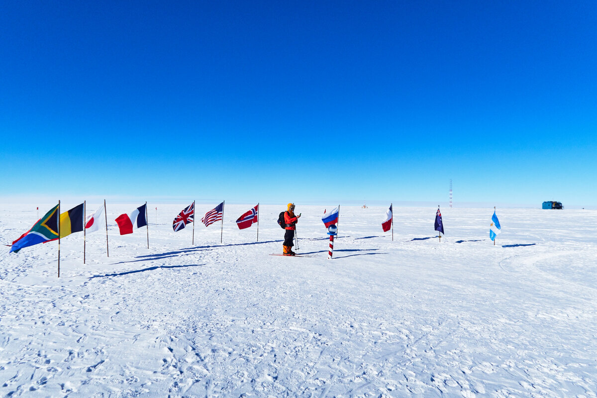Skier surrounded by flags of Antarctic Treaty nations