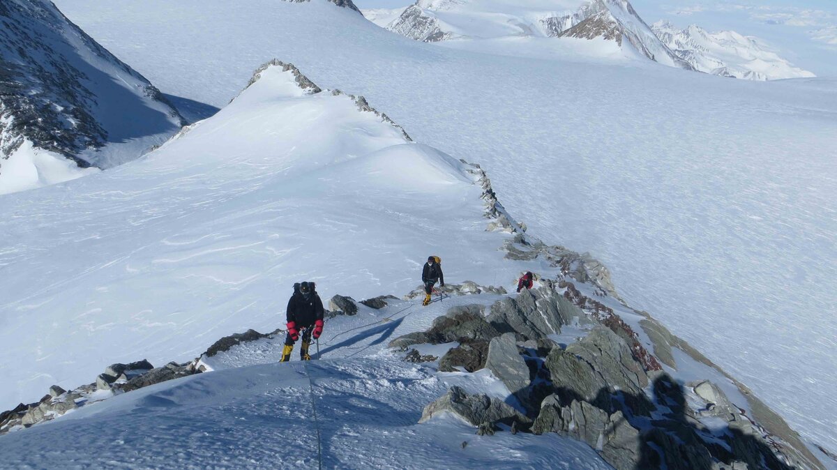 Roped team climbs the summit ridge