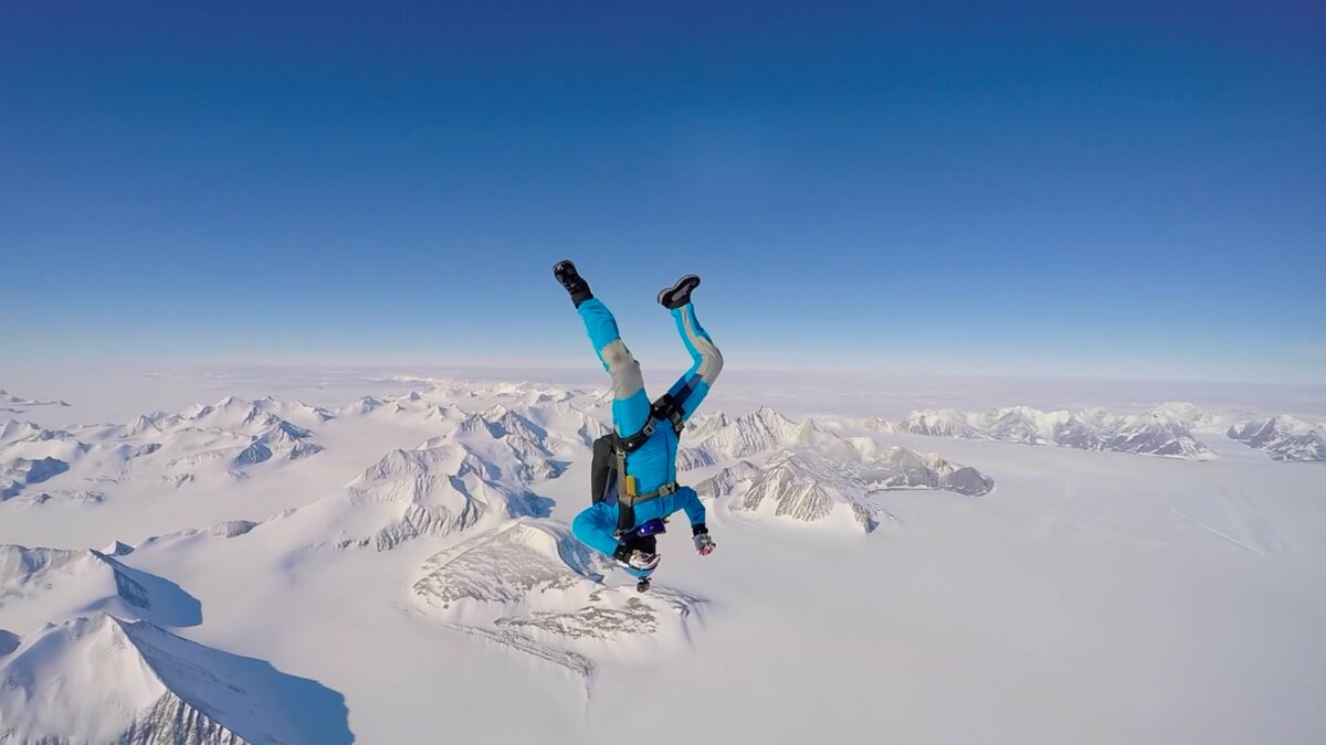 A skydiver hangs in the sky over Union Glacier