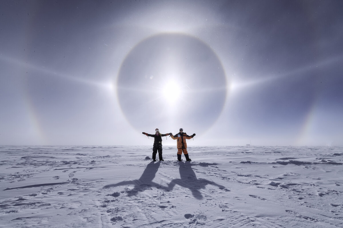 Two guests celebrate a stunning solar halo at the South Pole